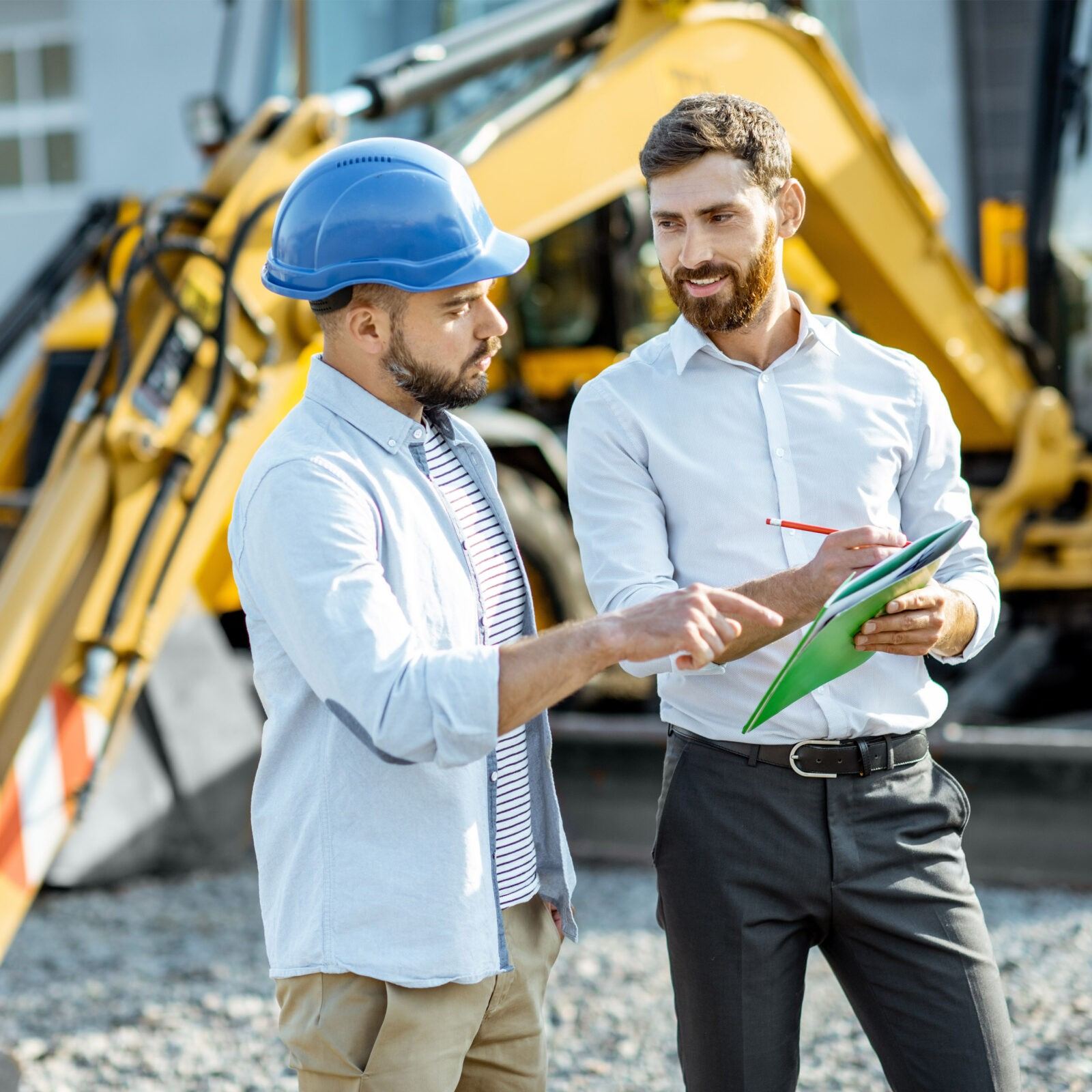 Contractor and advisor reviewing plans on site