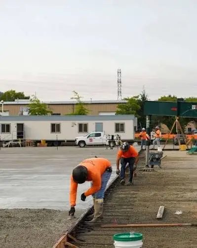Crews finishing a concrete pour on an active job site